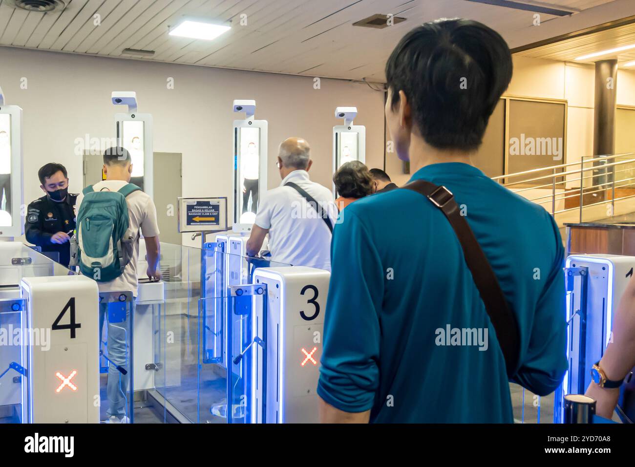 I turisti passano i cancelli elettronici, controllo automatico delle frontiere, self-service automatico eGates, verifica del visto presso gli arrivi dell'aeroporto di Giacarta Indonesia Foto Stock