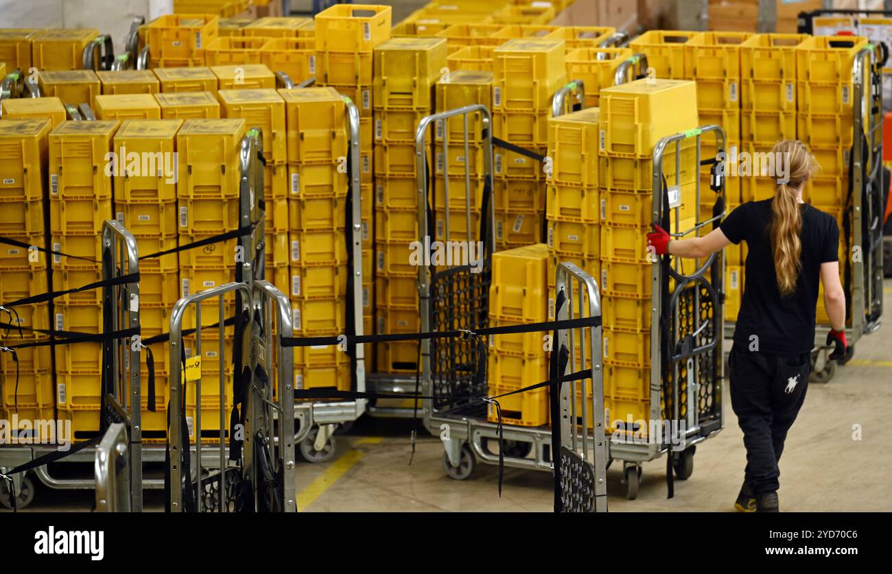 Erfurt Vieselbach, Germania. 25 ottobre 2024. Un dipendente trasporta posta nel centro postale della filiale Deutsche Post Erfurt nel villaggio merci Erfurt-Vieselbach (GVZ). Crediti: Martin Schutt/dpa/Alamy Live News Foto Stock