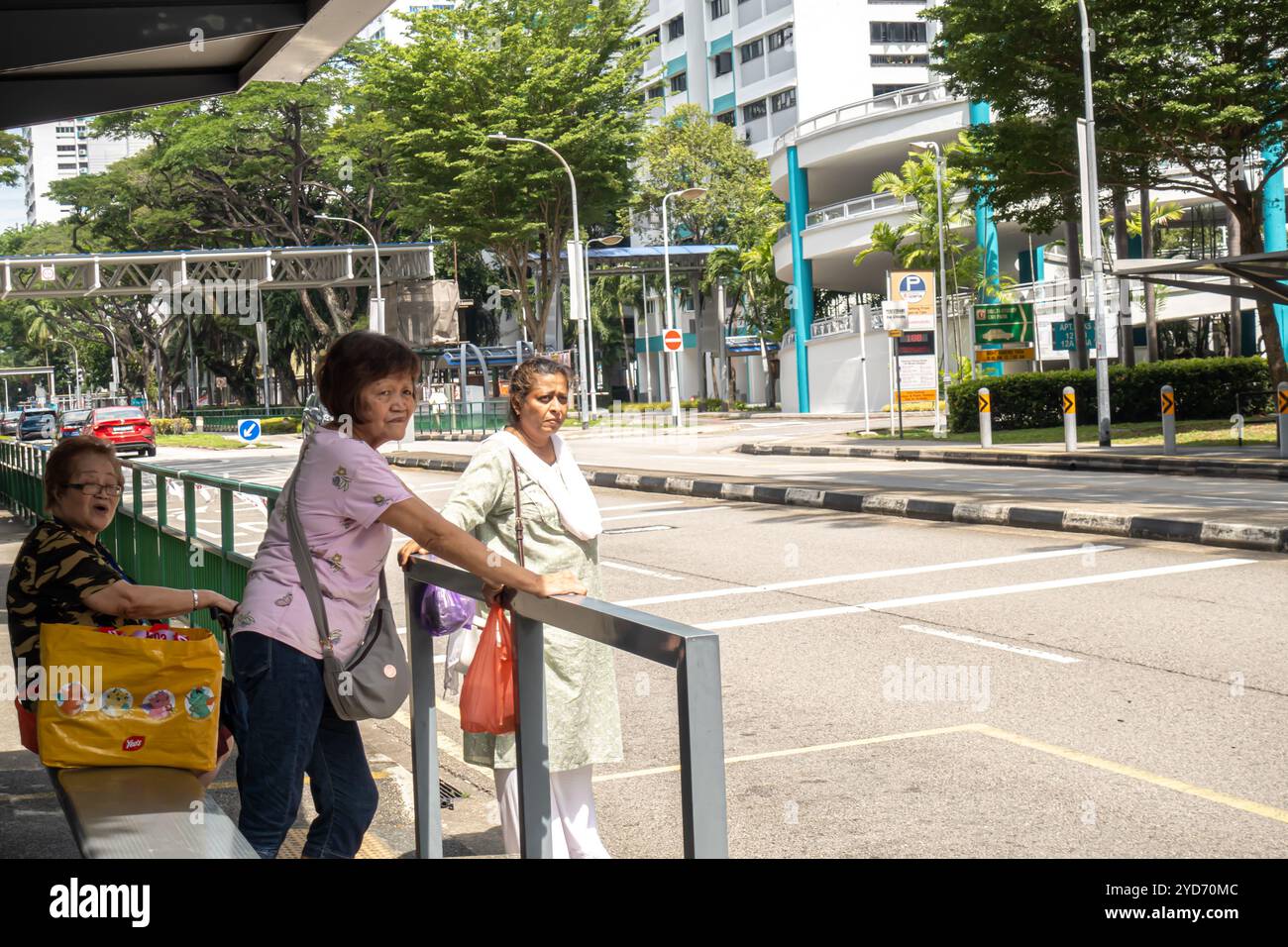 Donne anziane alla fermata dell'autobus in attesa di un autobus, trasporto pubblico a Marine Parade Singapore Foto Stock