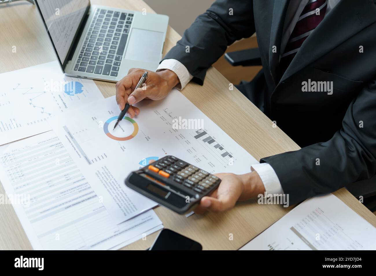 Commercialista che analizza i grafici di investimento fattura e premendo i pulsanti della calcolatrice sui documenti. Contabile Foto Stock