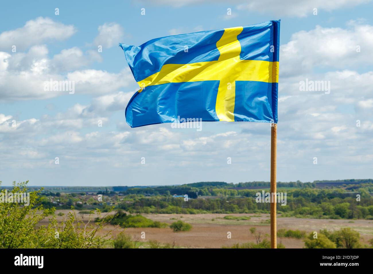 La bandiera nazionale della Svezia sventola nel vento nel cielo con le nuvole. Il concetto di relazioni internazionali. Foto Stock