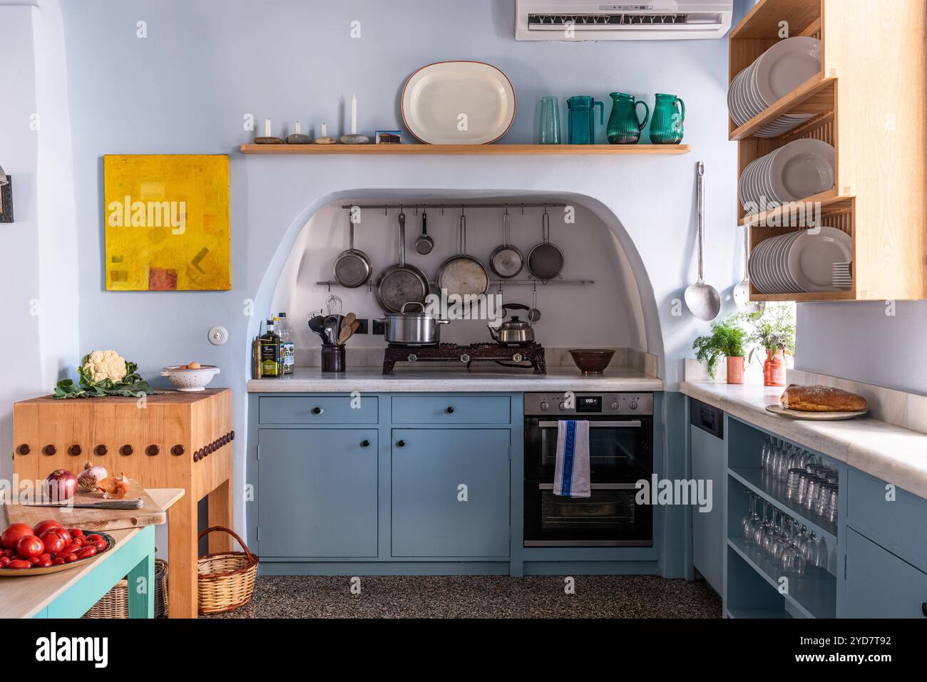 Cucina attrezzata con portapacchi a parete in una casa storica ristrutturata sull'isola di Tinos in Grecia Foto Stock