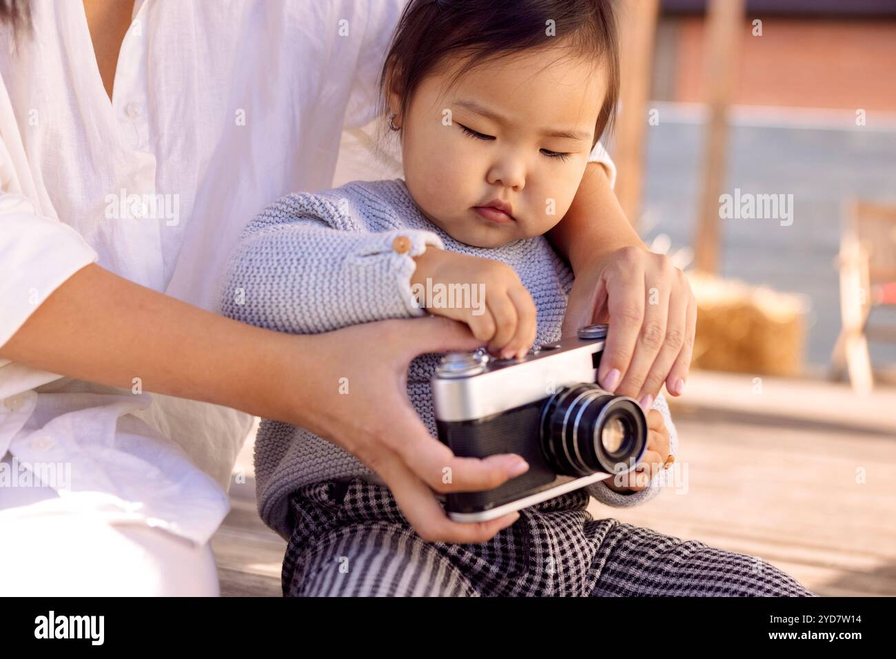 La donna asiatica e il suo bambino giocano nel cortile della casa Foto Stock