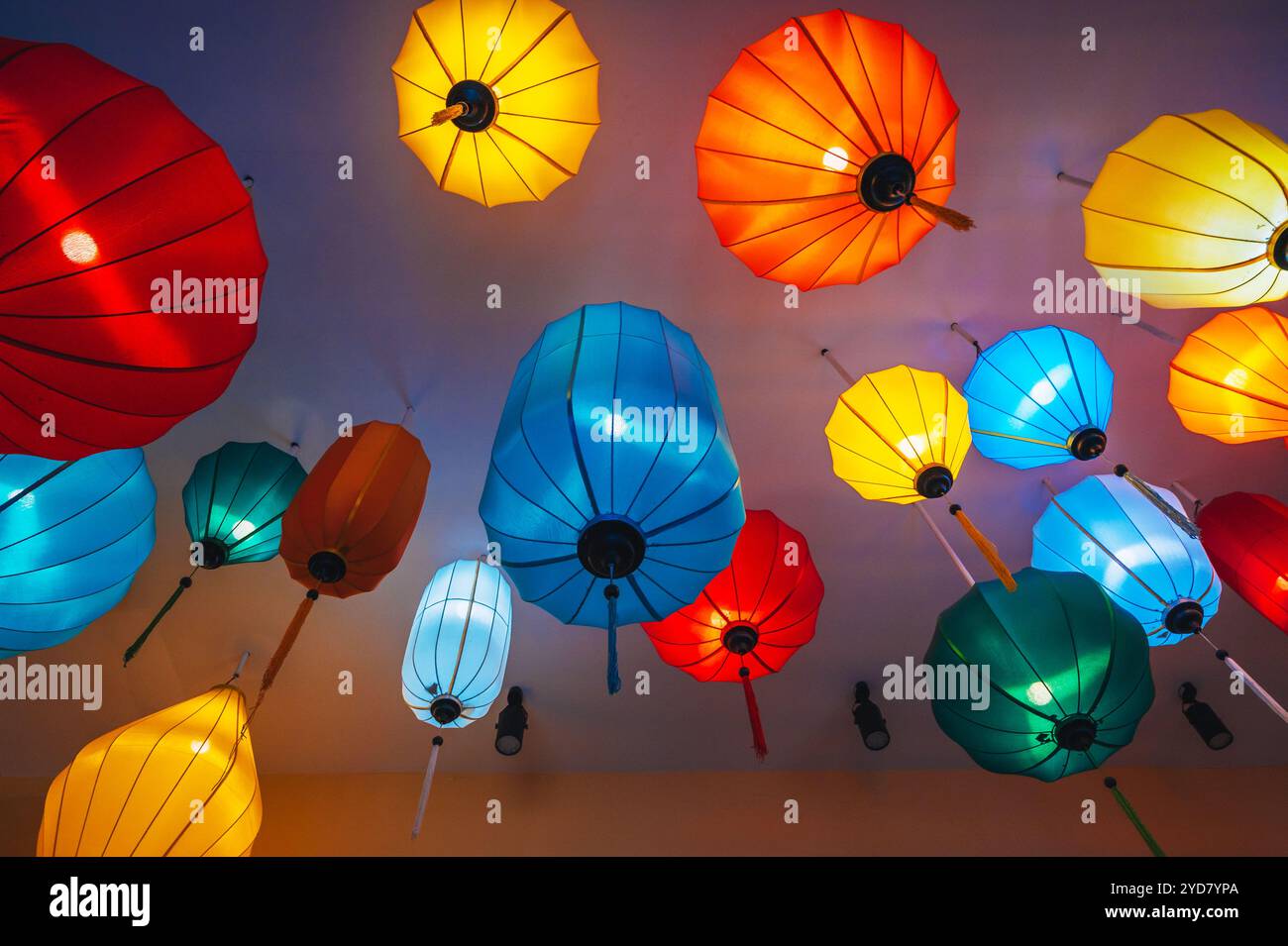 Tradizionali lanterne cinesi sospese in seta multicolore dal soffitto di un caffè asiatico per la decorazione degli interni Foto Stock