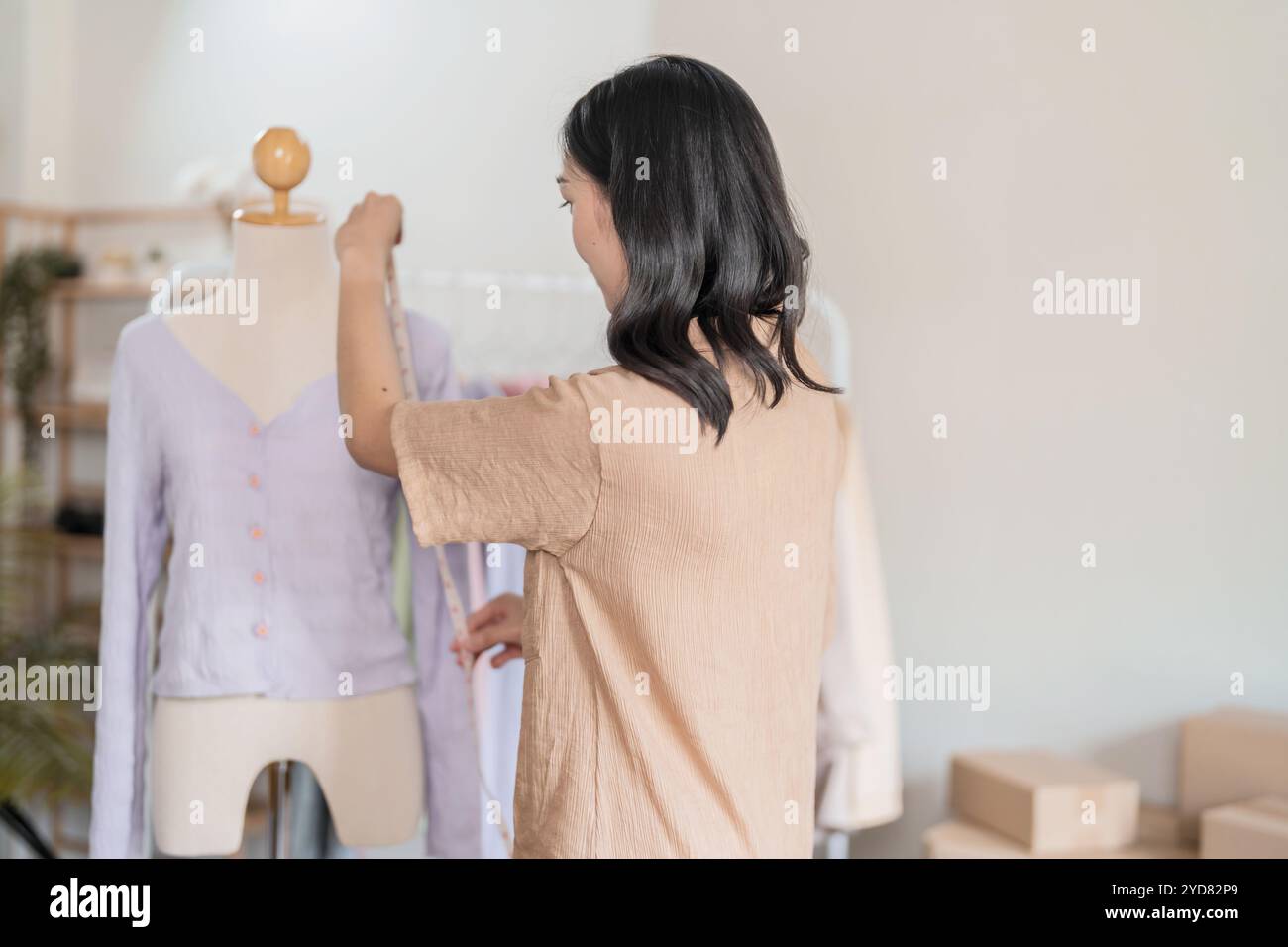 Donna sartoriale che lavora in sartoria elegante stilista sartoriale in studio di officina che disegna la nuova collezione Dressmaking e. Foto Stock