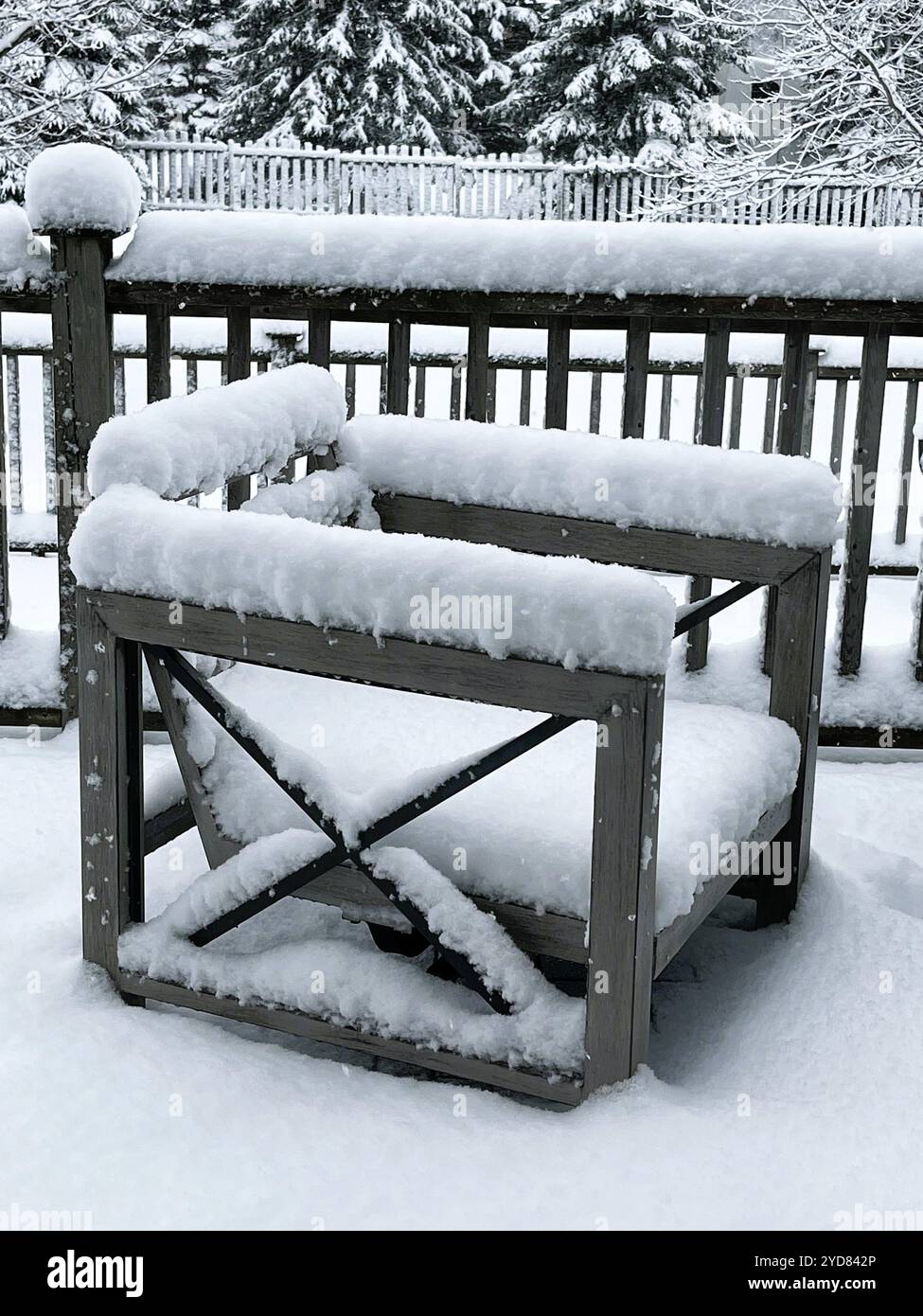 Neve bianca fresca si accumula sui mobili del patio su una veranda sul retro che segnala l'inizio dell'inverno. Foto Stock