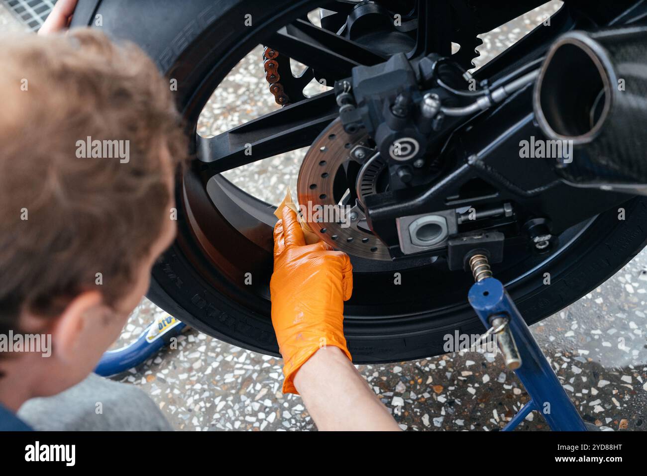 Giovane uomo che pulisce o lavora con BMW nero sportbike. Moto potente e moderno Foto Stock