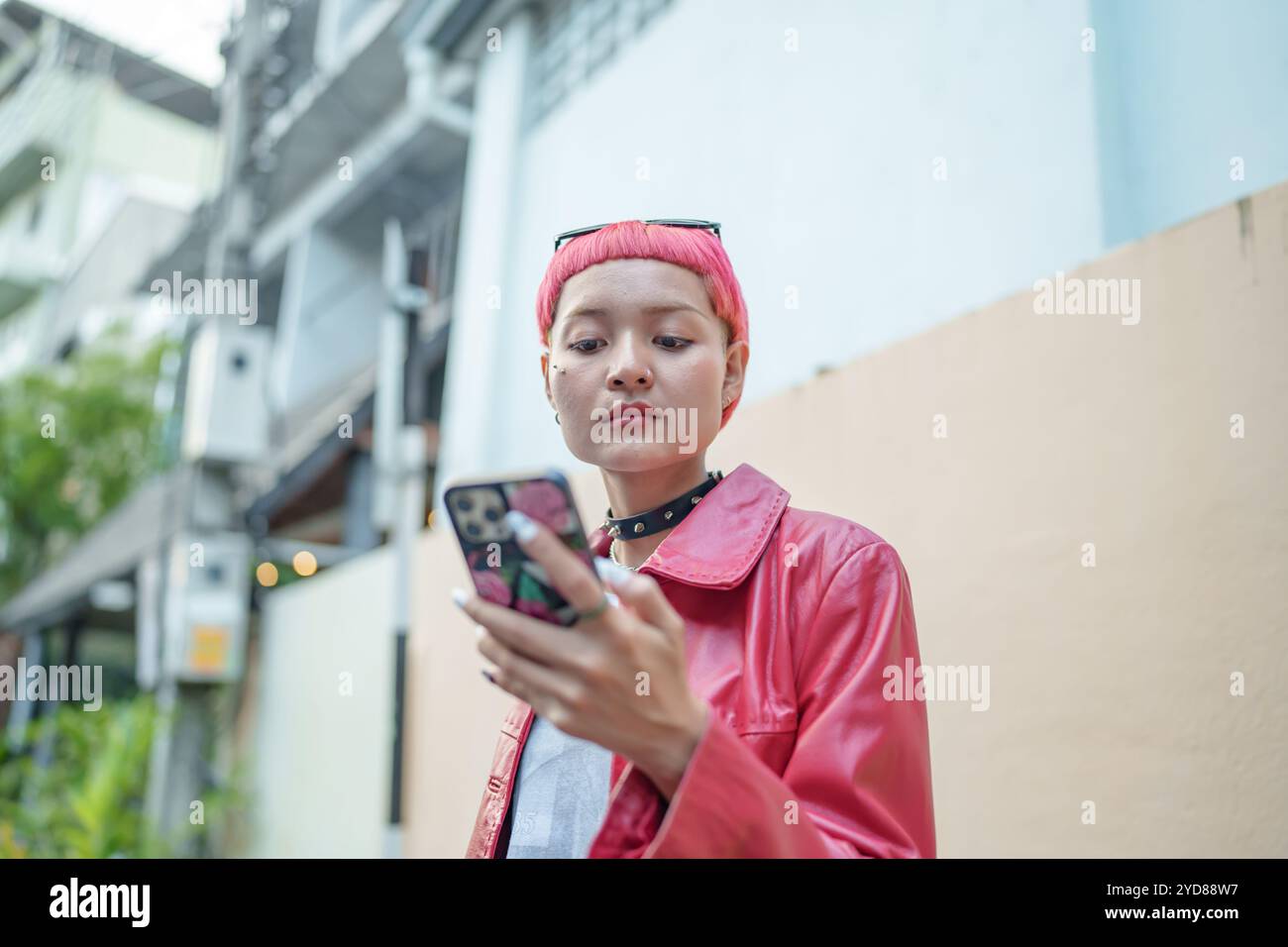 Viaggiatore Gen z ragazza moda in pelle con punk asiatico donna touristÂ in città strada ricerca posizione in applicazione mappa online s Foto Stock