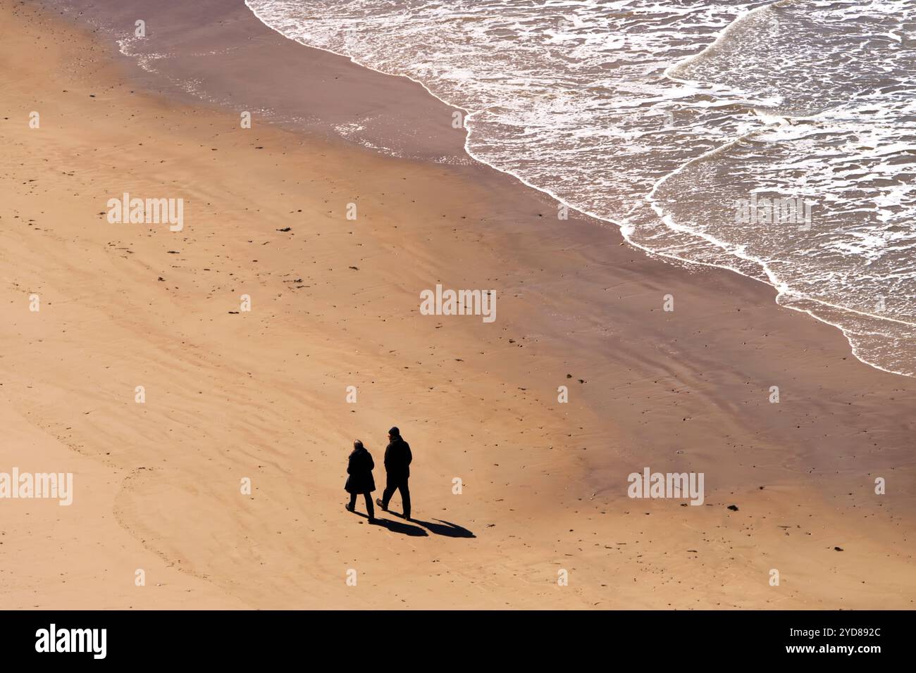 Due persone camminano sulla spiaggia Foto Stock