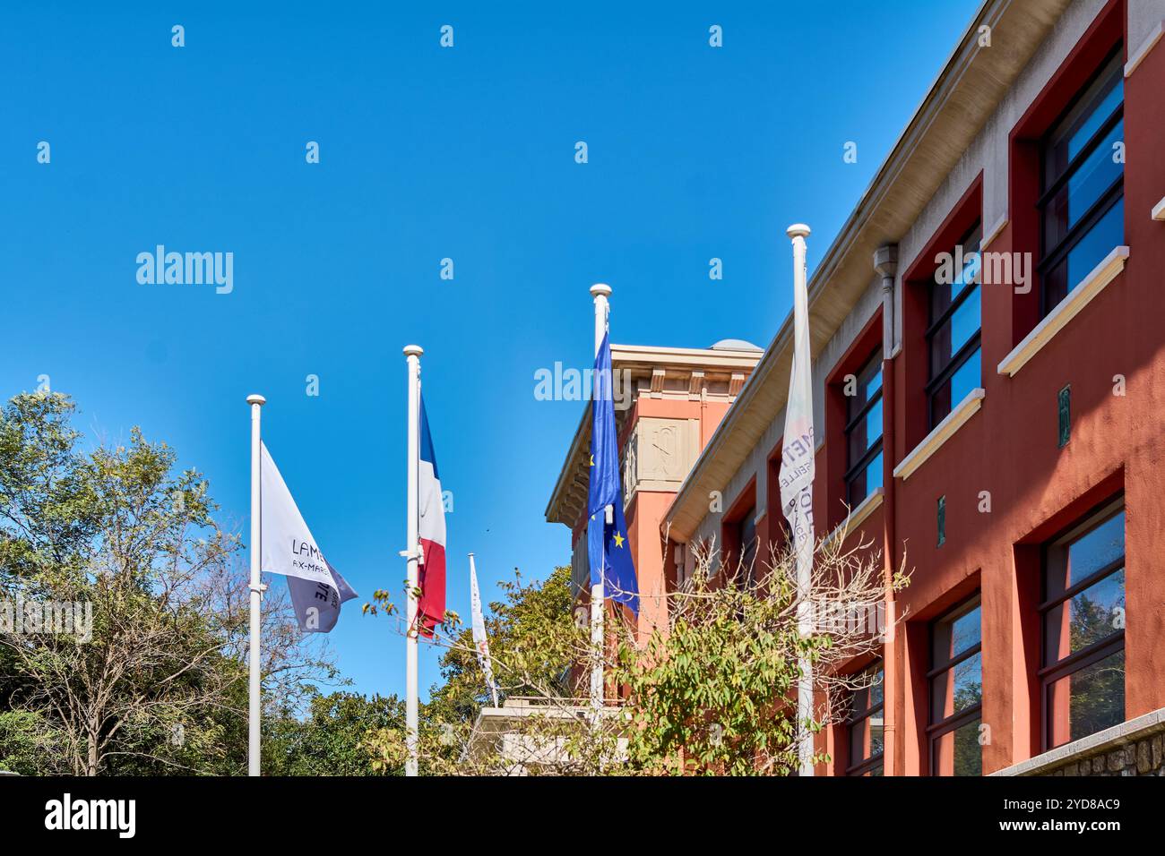 Marsiglia. Francia - 25 ottobre 2024: Bandiera francese ed europea con mancanza di vento su un albero in una strada a Marsiglia Francia Foto Stock