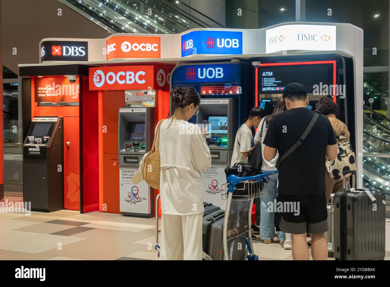 Aeroporto di Singapore Terminal 4 HSBC Bank ATM, viaggiatori che utilizzano ATM, turisti in fila per atm Foto Stock