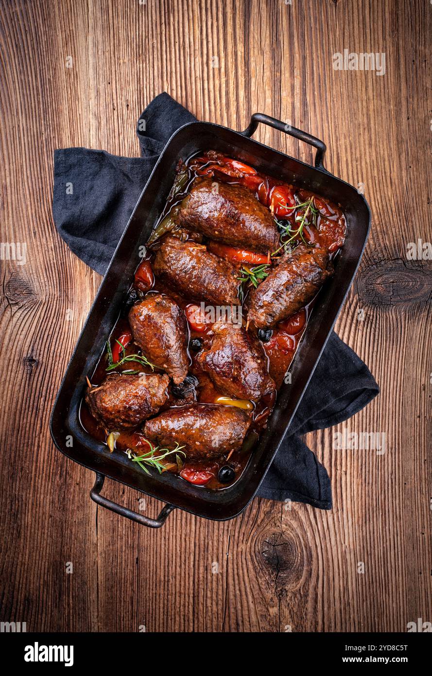 Tradizionale roulade di manzo wagyu tedesco a cottura lenta con verdure e olive servite in salsa di vino rosso piccante, vista dall'alto in una casseruola rustica Foto Stock