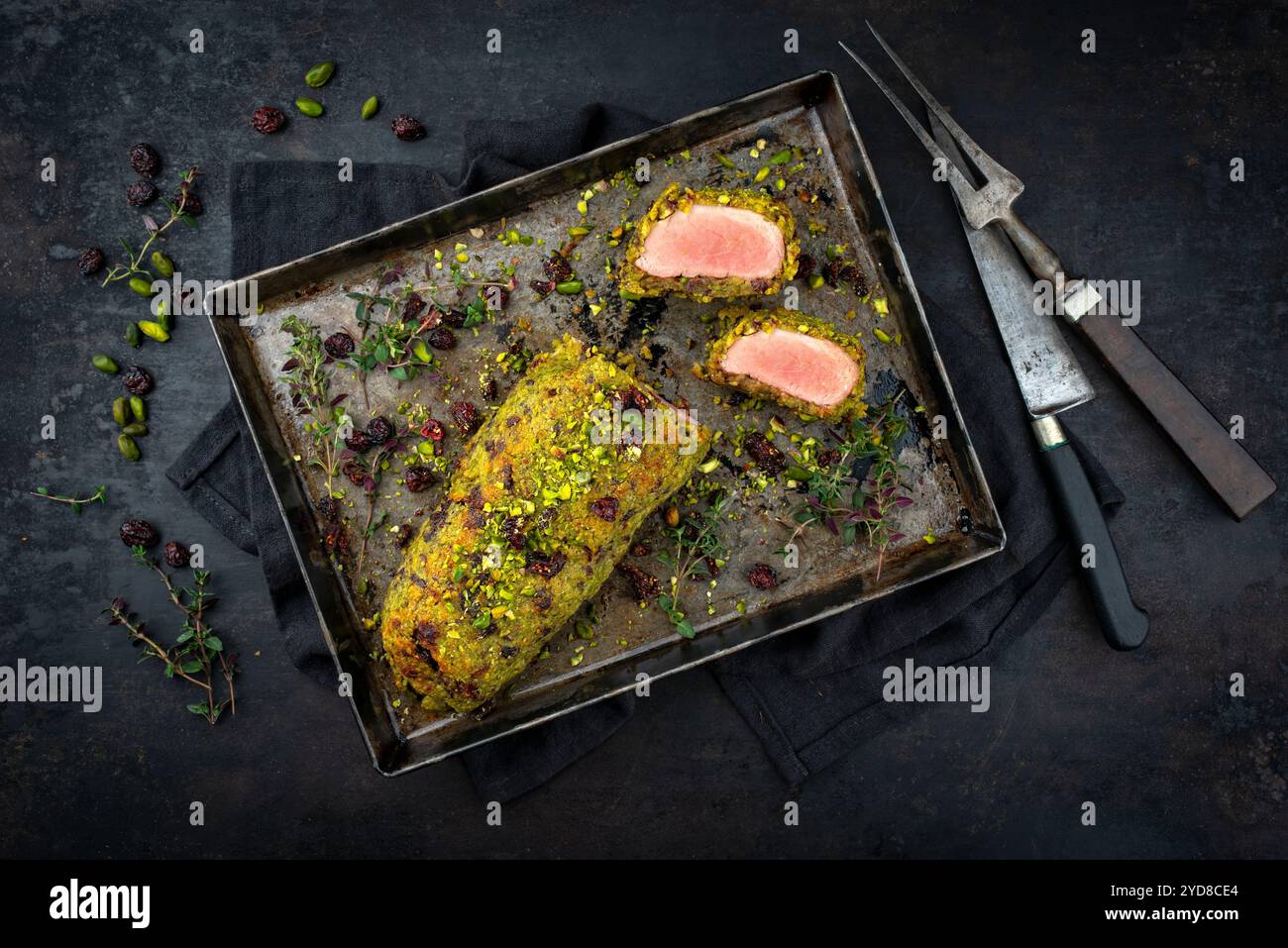 Filetto di maiale di mangalica fritto ricoperto di pistacchio crollato, parmigiano grattugiato e mirtilli rossi tritati serviti con patate principessa come vista dall'alto Foto Stock