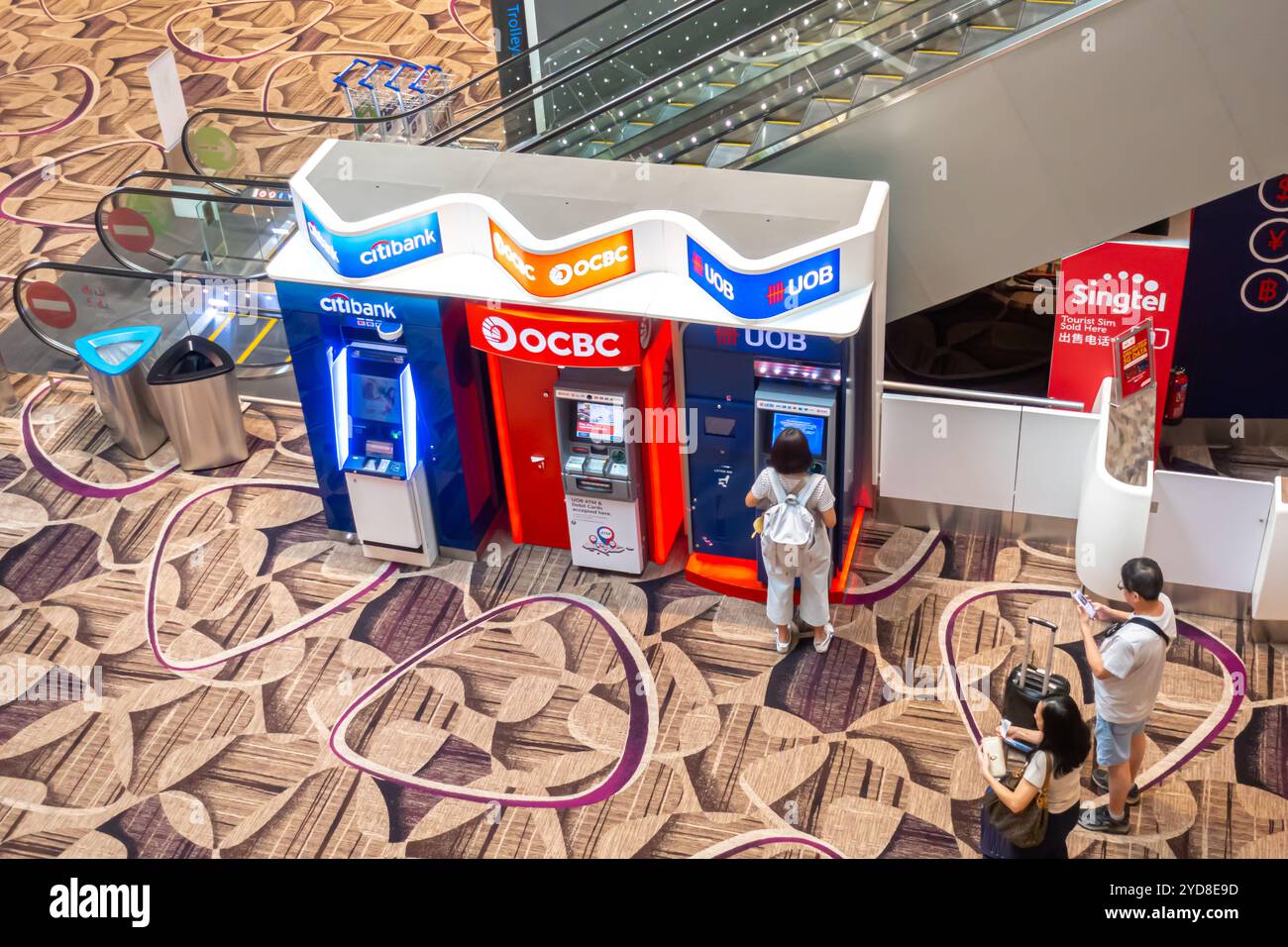 Aeroporto di Singapore Terminal 4 - ATM, viaggiatori che utilizzano ATM, turisti in fila per atm, bancomat - citibank, OCBC, UOB Foto Stock