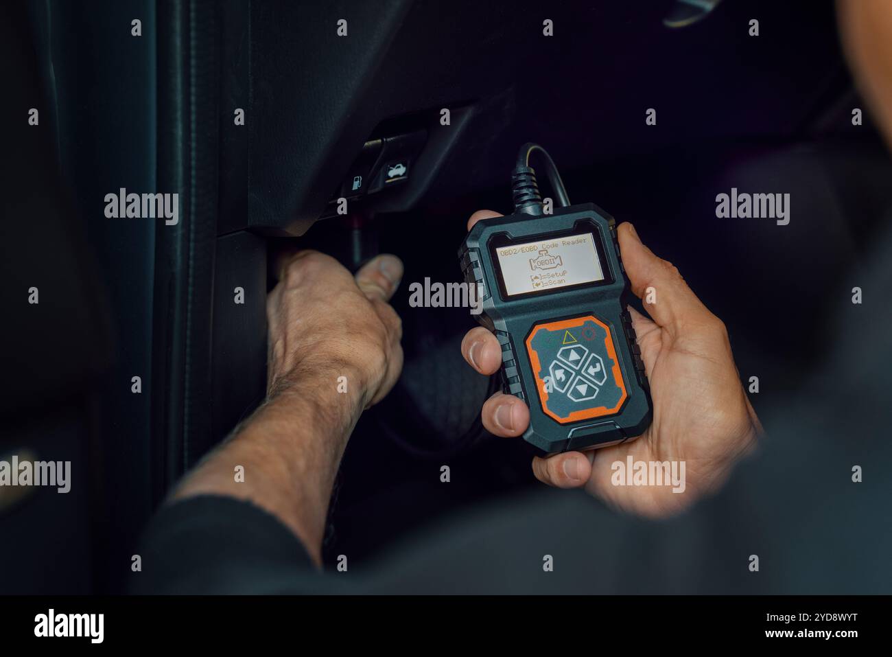 Meccanico di auto che utilizza lo scanner OBD2, strumento di lettura dei codici per controllare gli errori del motore e per la diagnostica Foto Stock