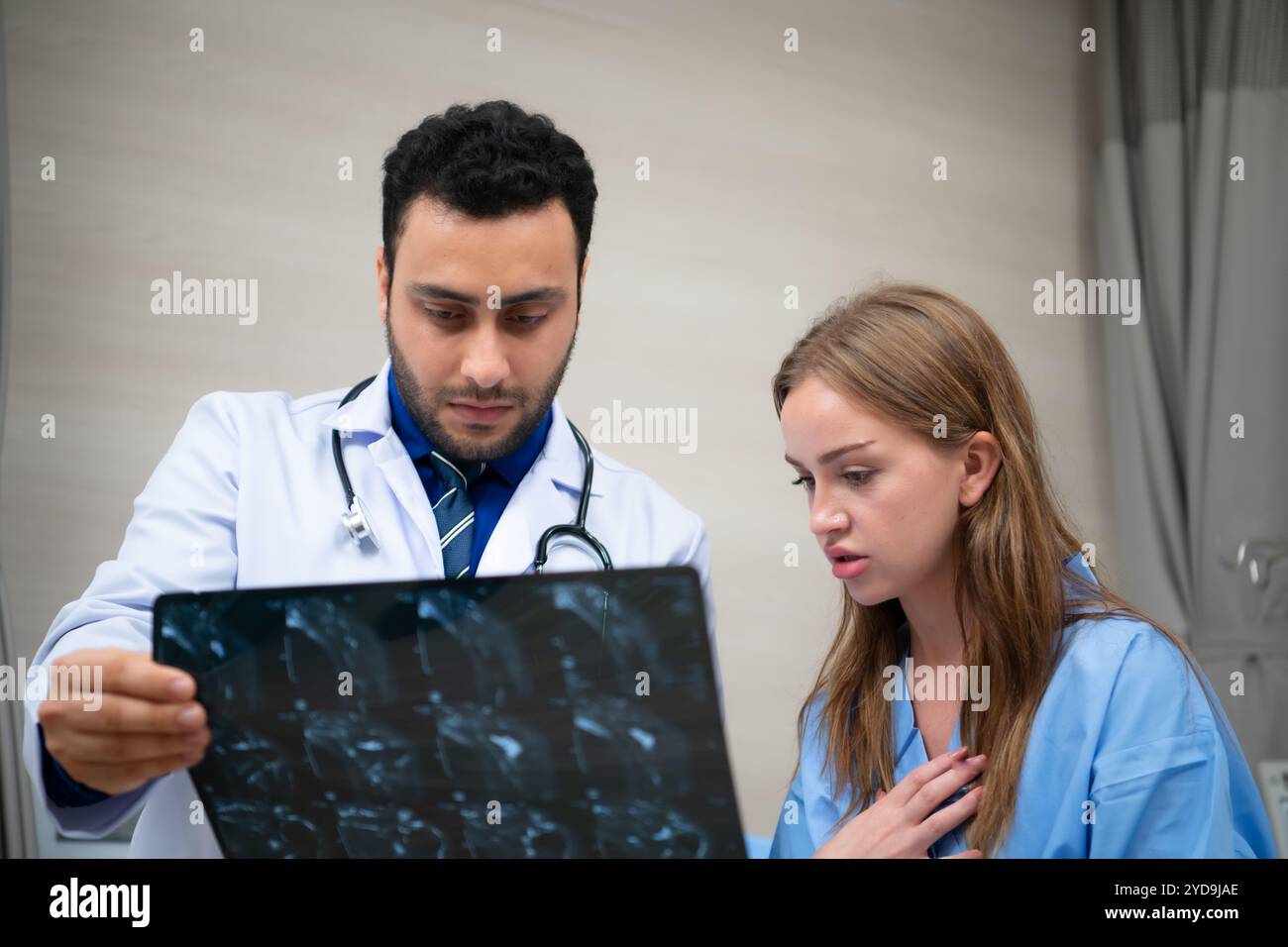 Medico vedere i risultati dei raggi X cerebrali di un paziente che ha subito una commozione cerebrale dopo l'incidente. e informare il paziente che il cervello Foto Stock