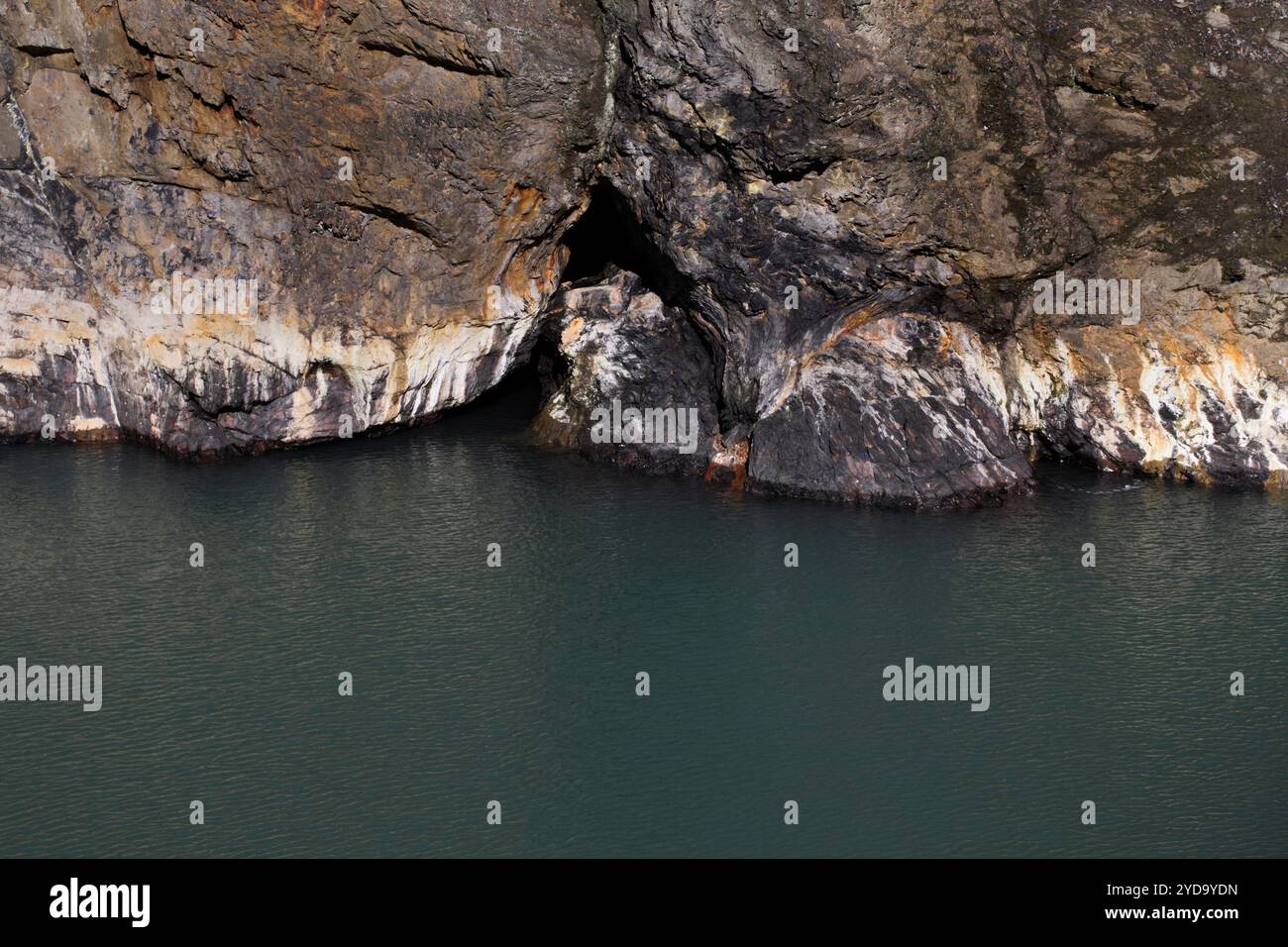 Strati di roccia e acqua durante l'alta marea, nel Witches Cauldron, o Pwll-Y-Wrach, sulla costa del Pemrokeshire o sul sentiero costiero. Foto Stock