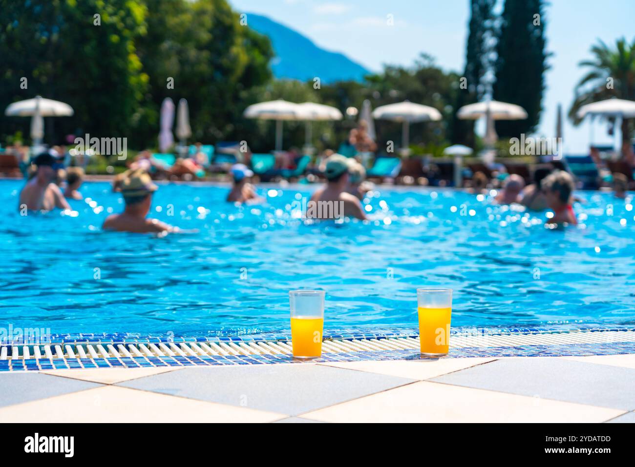 Bicchiere di succo d'arancia fresco accanto alla piscina Foto Stock