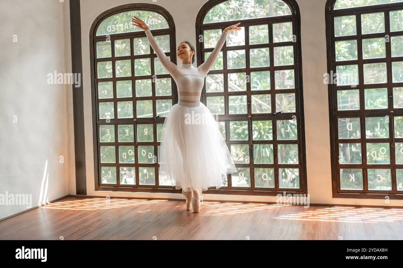 Esibizione creativa di ballerino girlÂ asiatico con gonna bianca che dimostra abilità di danza formazione di giovani ballerine gracefulÂ Foto Stock