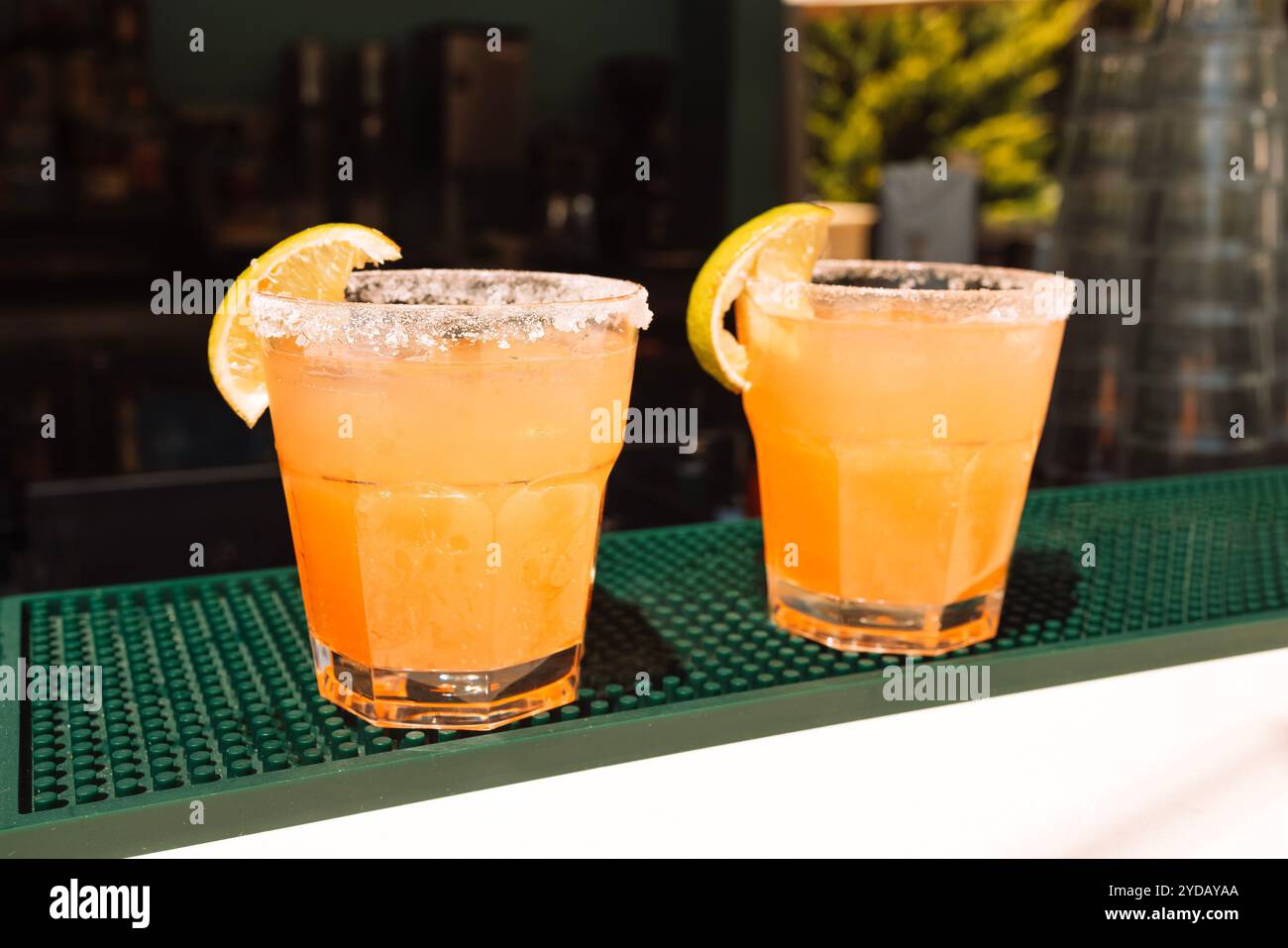 Due bicchieri con cocktail agli agrumi al bar. Deliziose bevande ghiacciate con fette di limone. Foto Stock