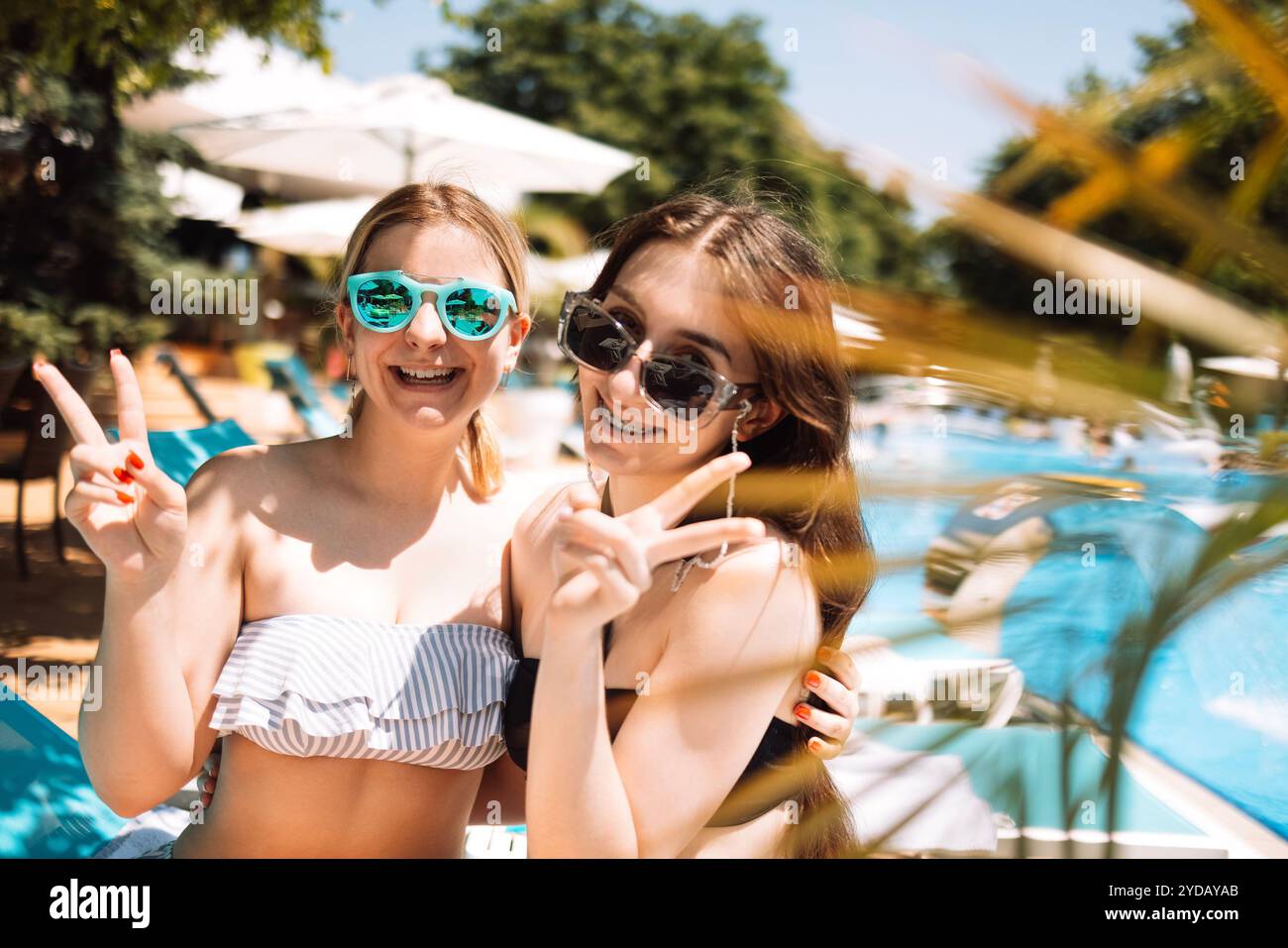 Due simpatici adolescenti in costume da bagno stanno ridendo in piscina. Amica sorridente Foto Stock