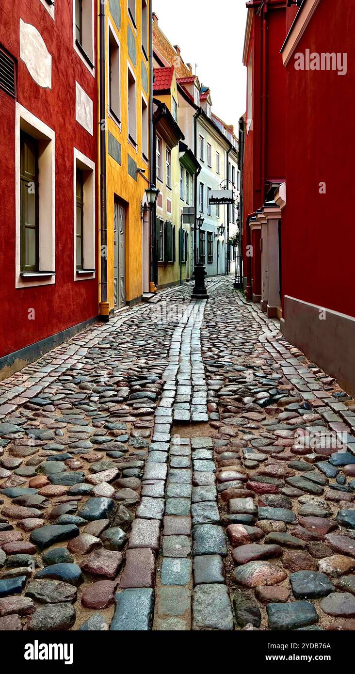 Affascinante e stretta strada acciottolata con edifici vibranti nella città vecchia di una città europea - Immagine stock catturata con smartphone