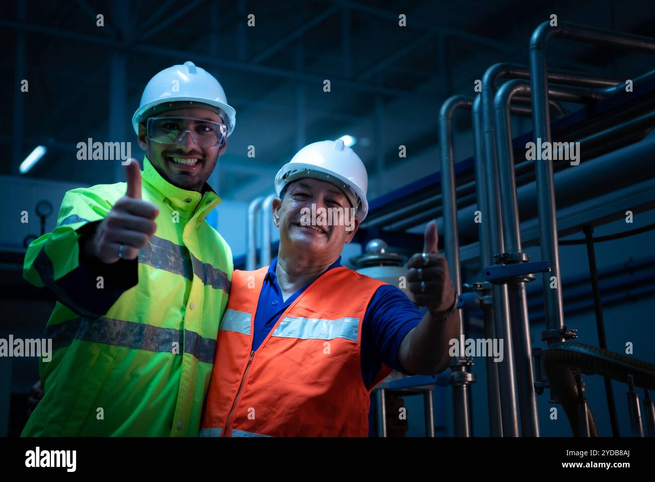 Ingegnere capo dell'impianto meccanico che ispeziona la manutenzione della macchina con i tecnici di fabbrica Foto Stock