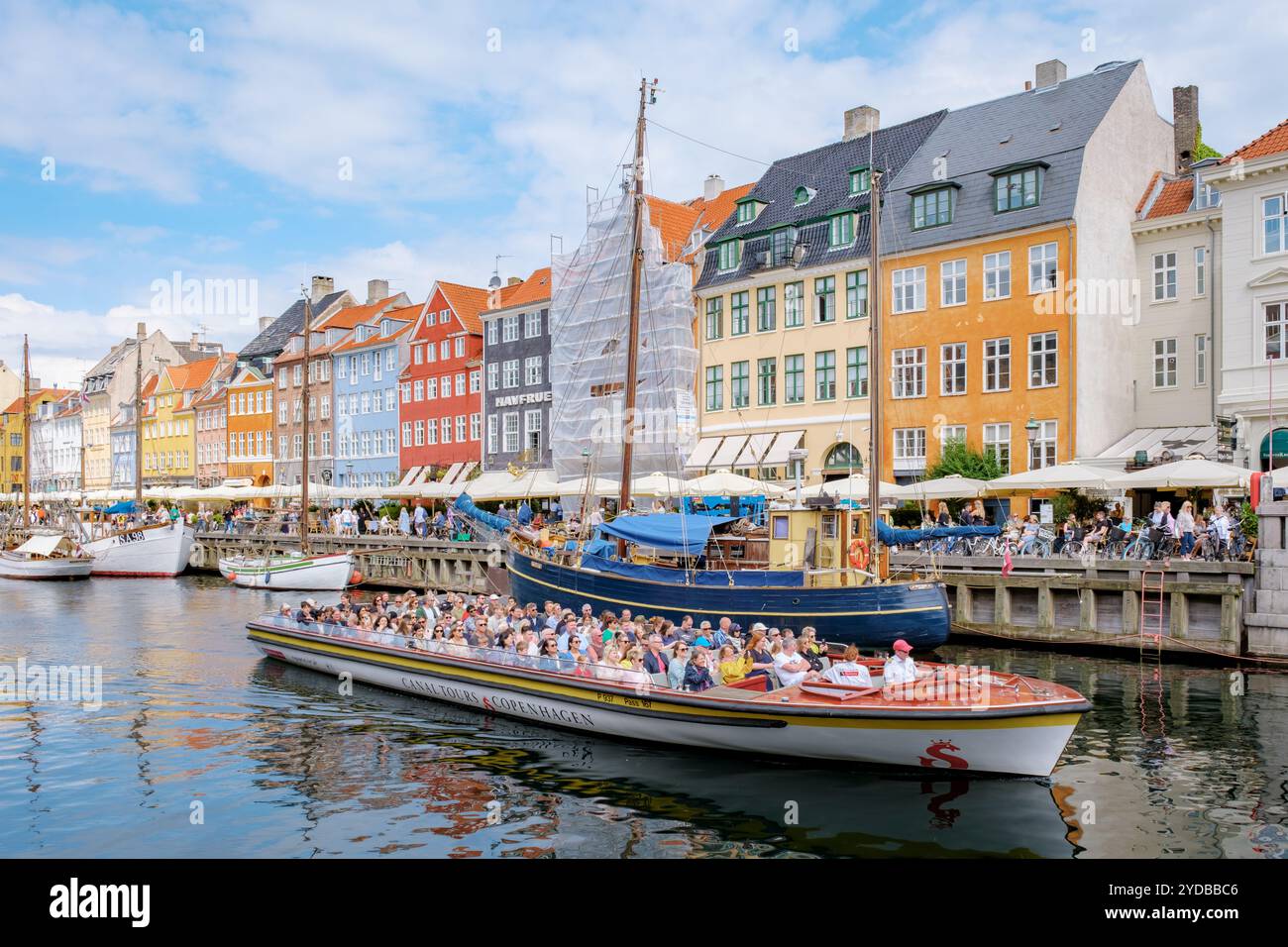 Copenaghen Danimarca 21 luglio 2024, Una barca sul canale piena di turisti naviga davanti a edifici colorati di Copenaghen, Danimarca. Il sole splende e il Foto Stock