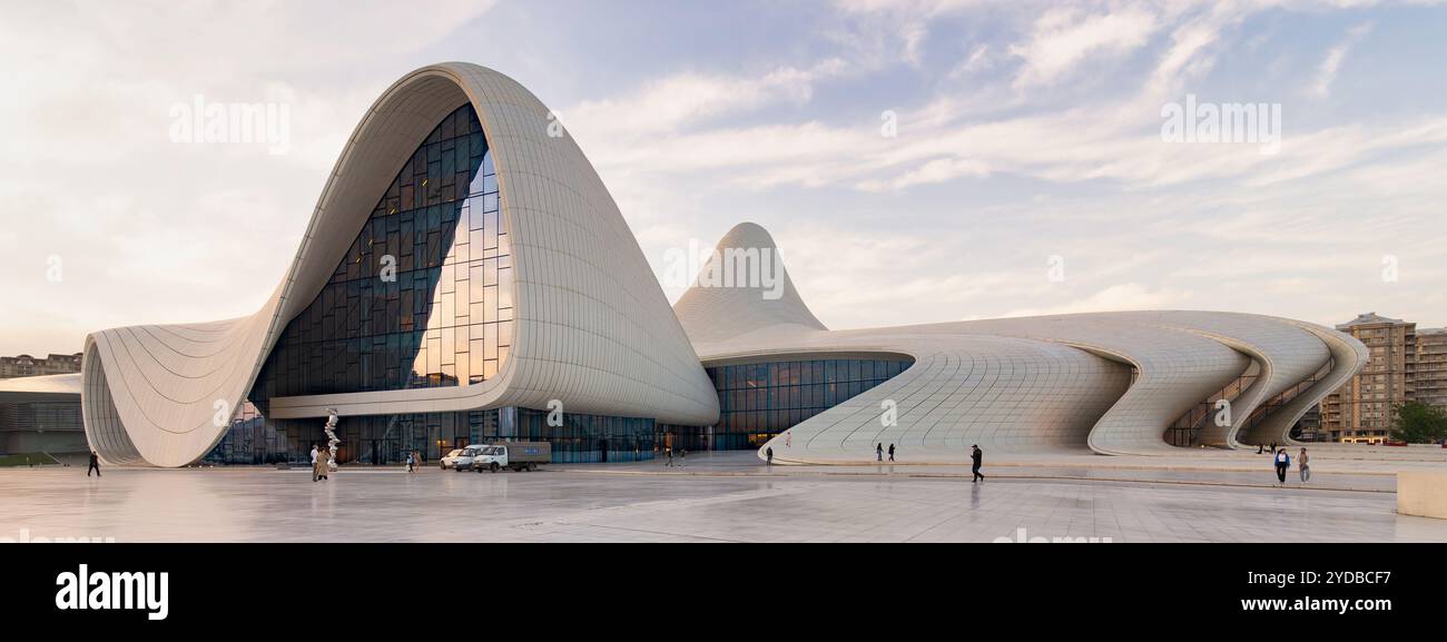 Baku, Azerbaigian - 11 maggio 2024: Il centro Heydar Aliyev mette in mostra il suo design fluido unico e le sue linee angolari sorprendenti, inondato dalla calda luce del tramonto Foto Stock