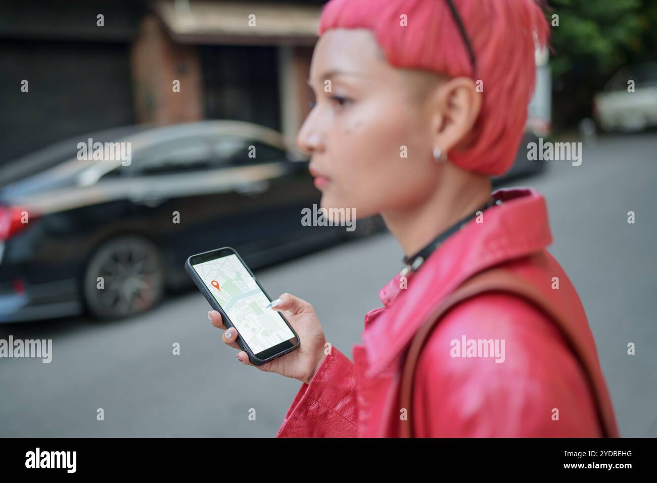 Viaggiatore Gen z ragazza moda in pelle con punk asiatico donna touristÂ in città strada ricerca posizione in applicazione mappa online s Foto Stock