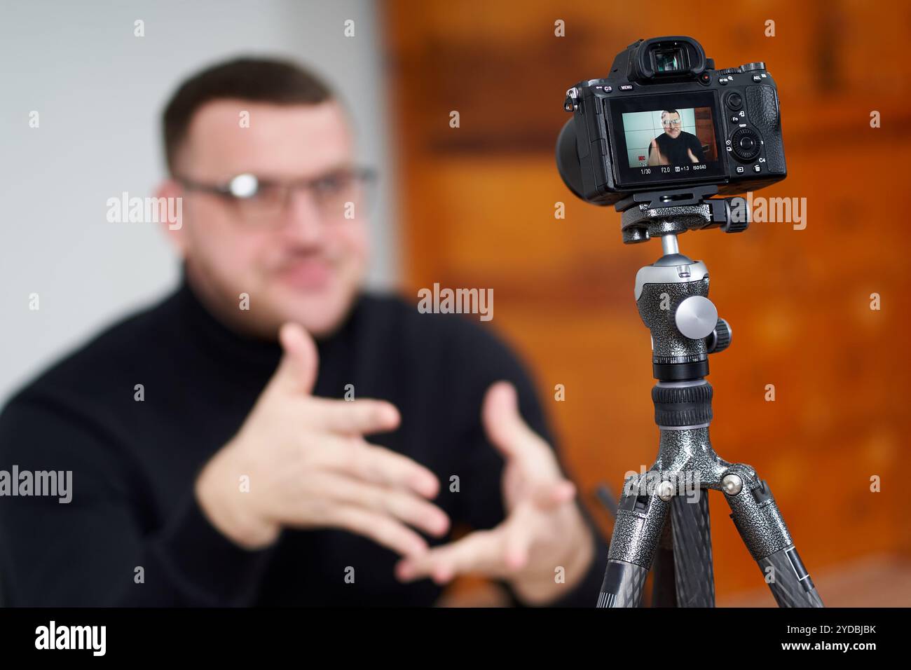 Uomo che filma video blog con fotocamera con treppiede per follower online. Nei social media, Influencer, nuova tecnologia e Internet conc Foto Stock