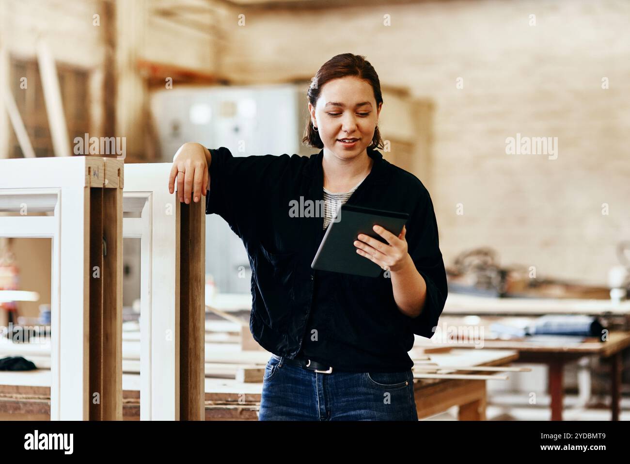 Officina, falegname e donna con tablet per la lettura, la ricerca e le informazioni sulle punte in legno. Piccola impresa, donna e costruttore con il digitale Foto Stock