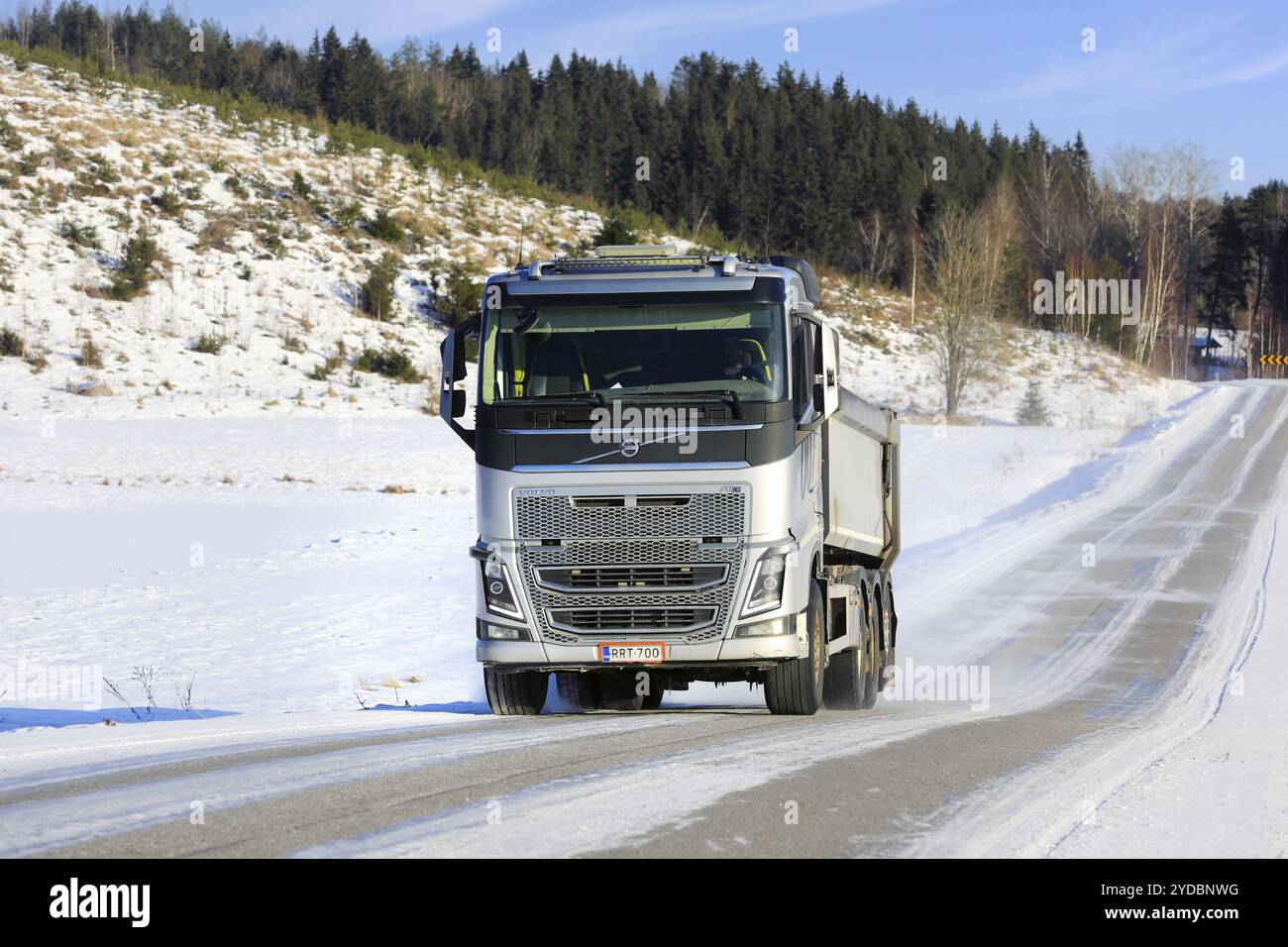 Camion ghiaia Volvo FH argentato in velocità su strade rurali in una giornata di sole d'inverno. Salo, Finlandia. 10 febbraio 2024 Foto Stock