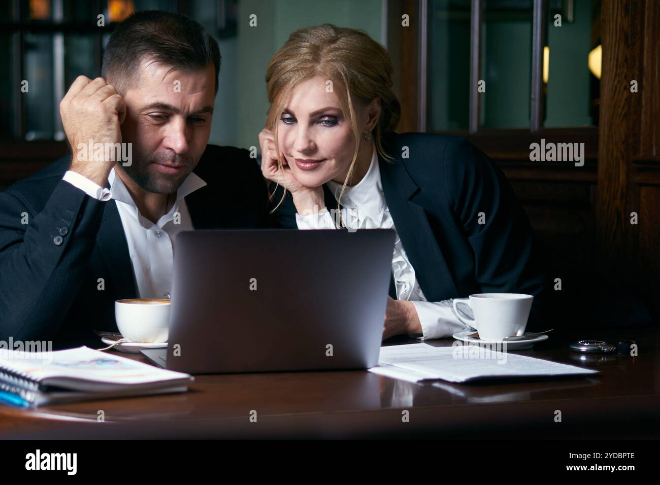 Uomini d'affari felici che lavorano insieme su un notebook in un ristorante Foto Stock