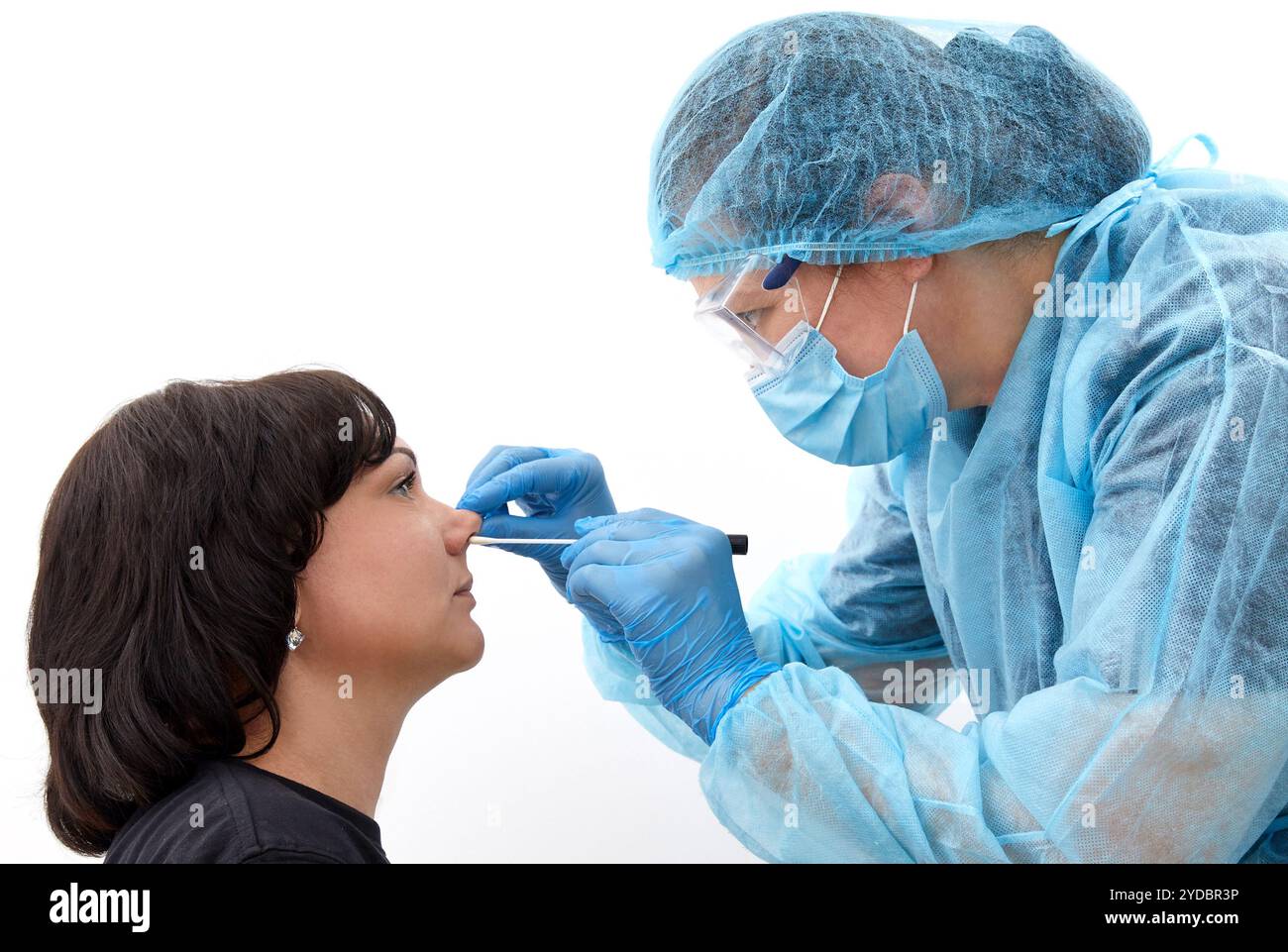 Medico in tuta protettiva che prende una gola e un tampone nasale da un paziente per verificare la possibile infezione da coronavirus o covid Foto Stock