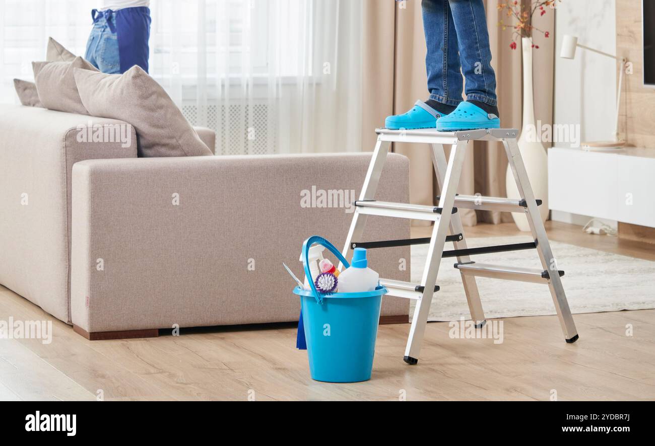 Vista ritagliata della scala di arrampicata uomo per pulire il soffitto. Concetto di servizio di pulizia Foto Stock