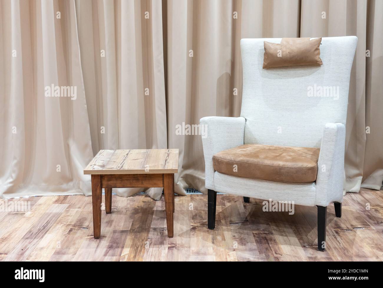 Interno di una moderna camera d'hotel con poltrona e tavolino da caffè in legno Foto Stock