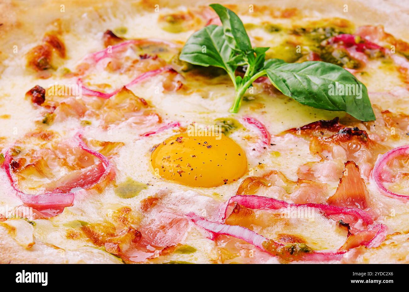Pizza italiana con tuorlo d'uovo, prosciutto e cipolla Foto Stock