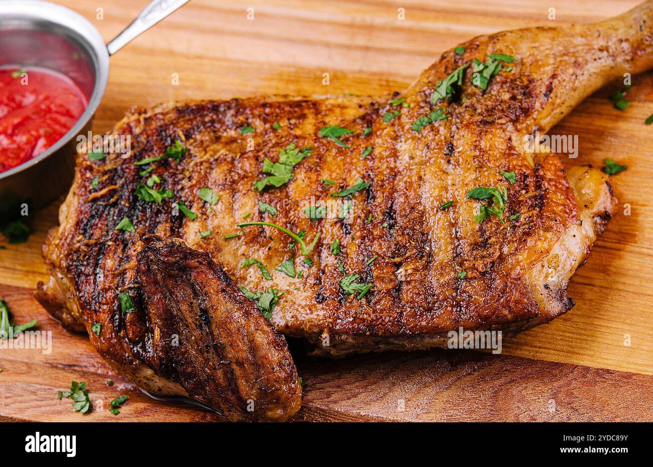 grigliata barbecue croccante gamba di pollo sul bordo di legno Foto Stock