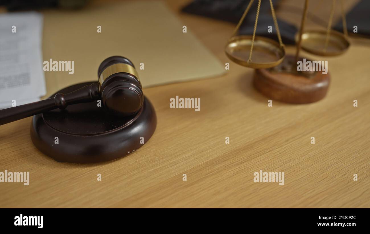 Il martelletto e le scale di giustizia su una scrivania di legno nell'ufficio di un avvocato simboleggiano procedimenti legali, giudizi e leggi. Foto Stock