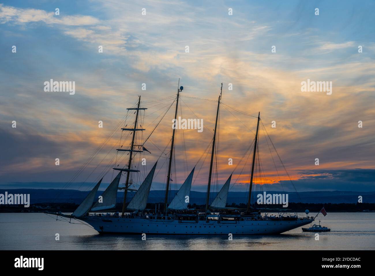 Sicilia, Italia. 25 ottobre 2024. Star Flyer, una nave Star Clipper, lascia il porto mentre il sole tramonta sul porto. Si tratta di moderne navi da crociera create per i passeggeri che amano le tradizioni dell'era delle navi a vela. Le navi sono lunghe 115 metri e trasportano 166 ospiti. Autunno a Siracusa, Sicilia, Italia. Crediti: Guy Bell/Alamy Live News Foto Stock