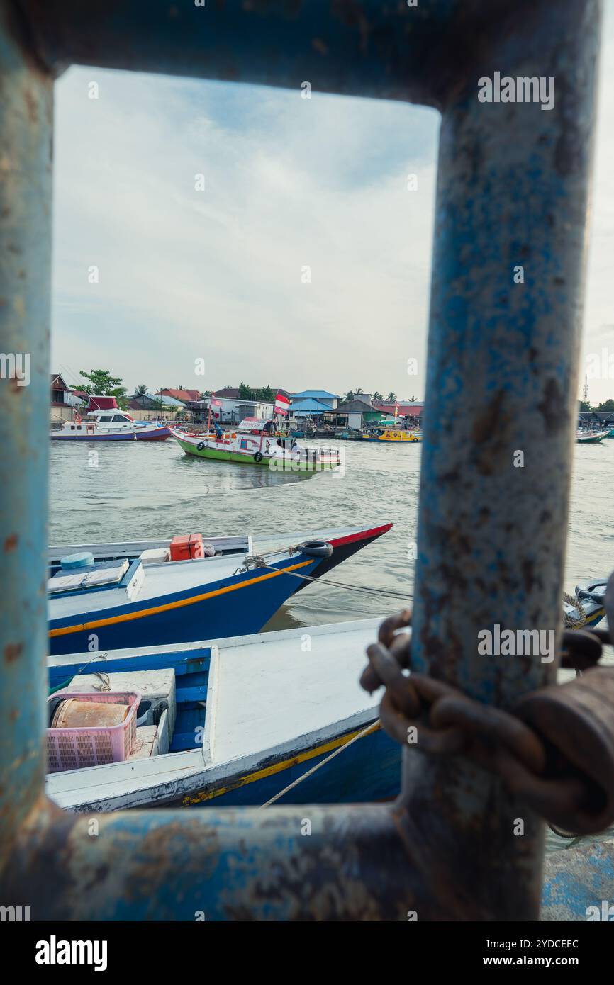 Balikpapan, Borneo Orientale, Indonesia - 19 settembre. Una barca blu è nell'acqua accanto a un edificio Foto Stock