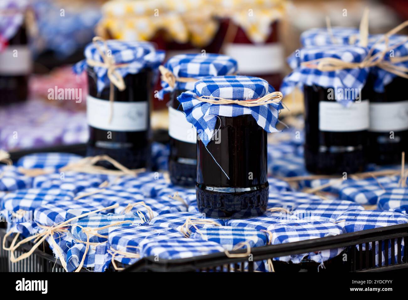 Molti barattoli per conserve con marmellata di scuro in un mercato. Inquadratura orizzontale Foto Stock