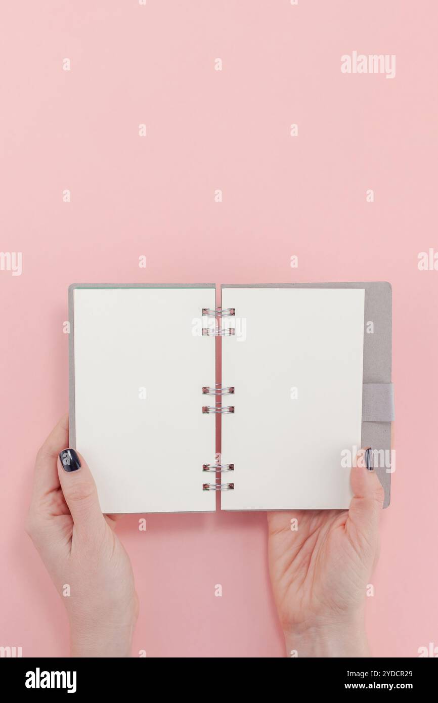 Donna mani con mockup di blocco note vuoto Foto Stock