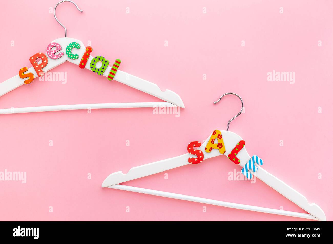 Appendiabiti bianchi con testo di vendita su sfondo rosa Foto Stock