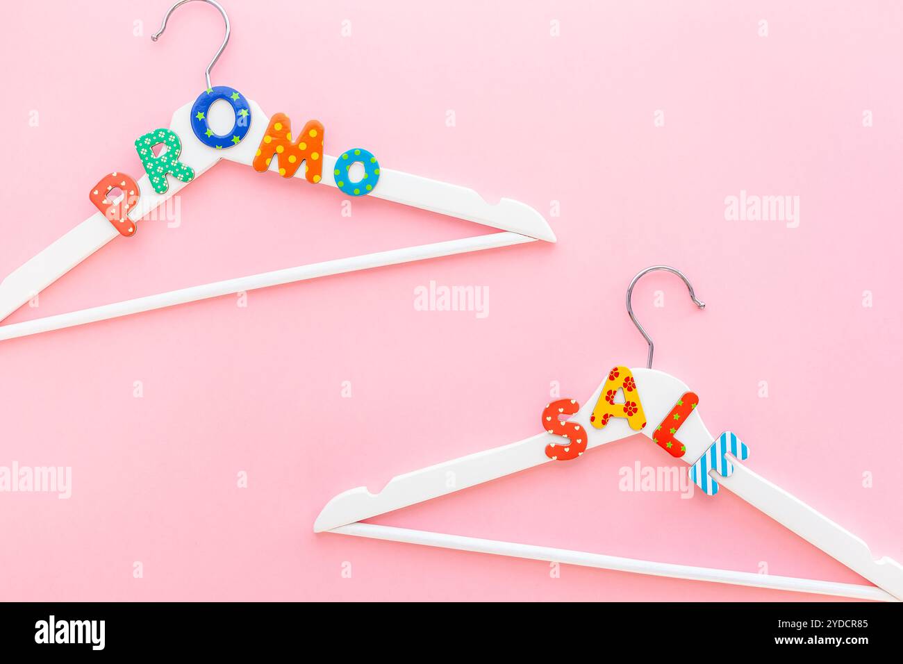 Appendiabiti bianchi con testo di vendita su sfondo rosa Foto Stock