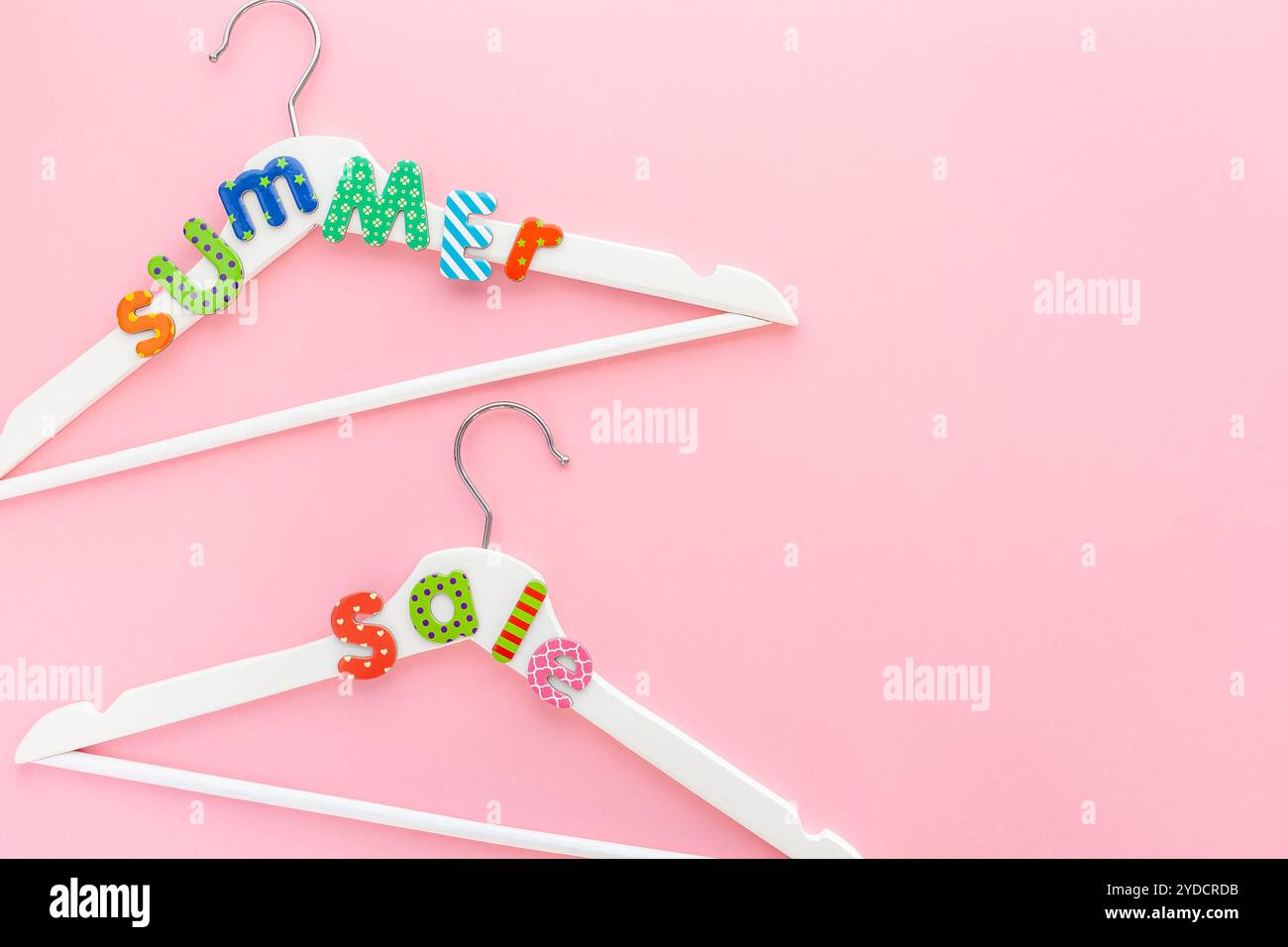 Appendiabiti bianchi con testo di vendita su sfondo rosa Foto Stock