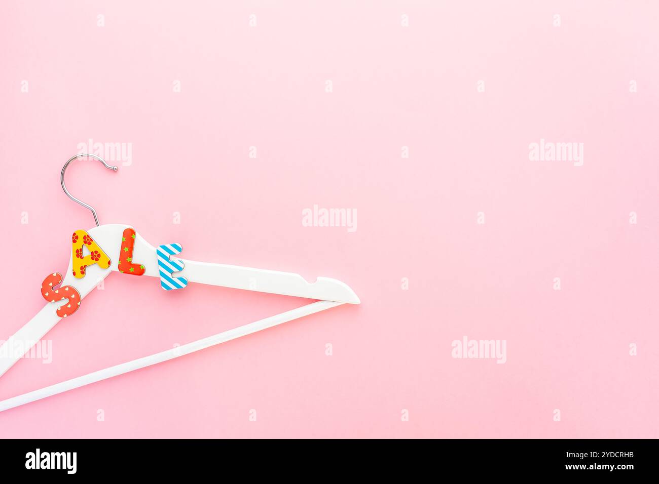 Appendiabiti bianchi con testo di vendita su sfondo rosa Foto Stock