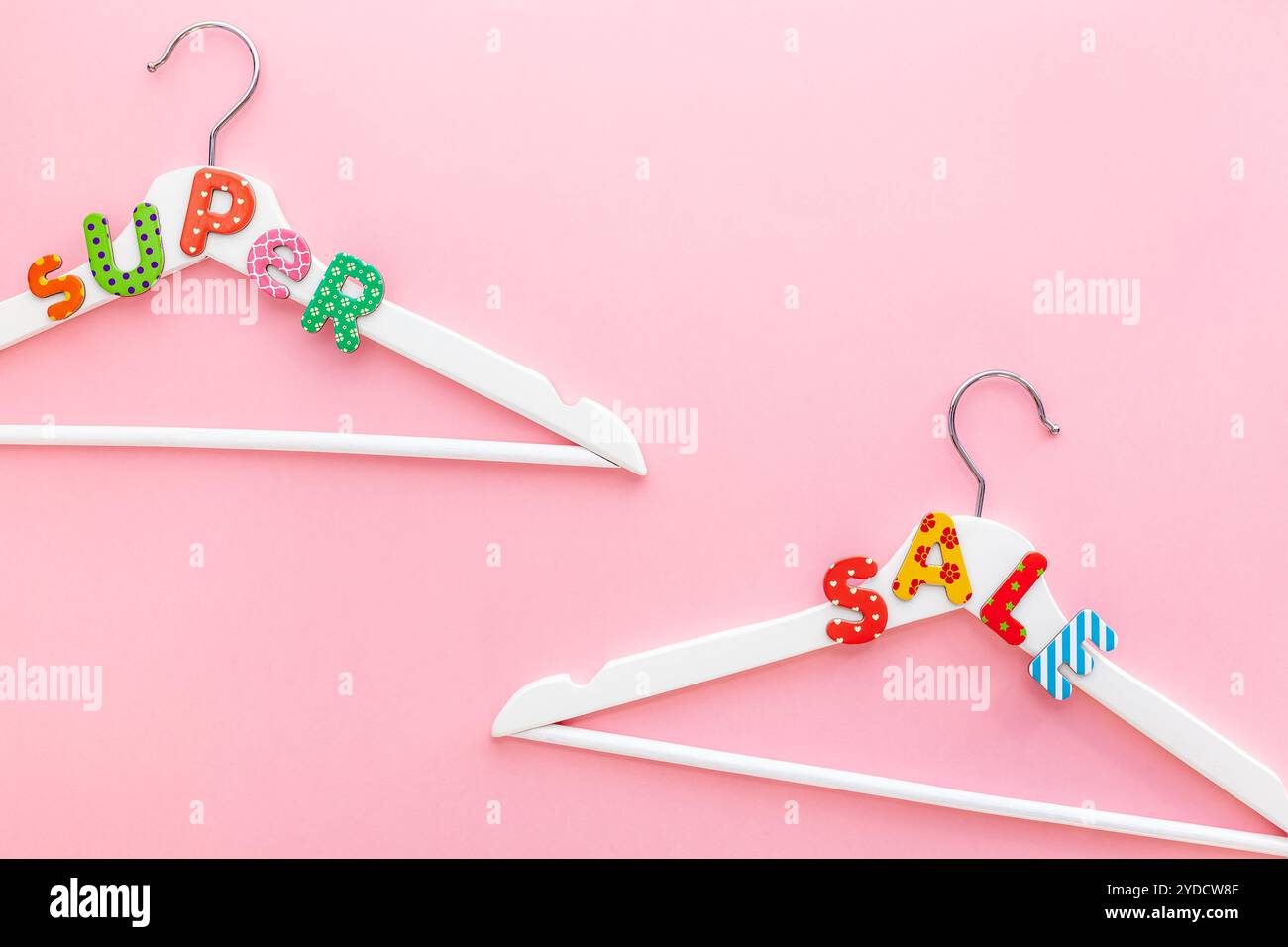 Appendiabiti bianchi con testo di vendita su sfondo rosa Foto Stock