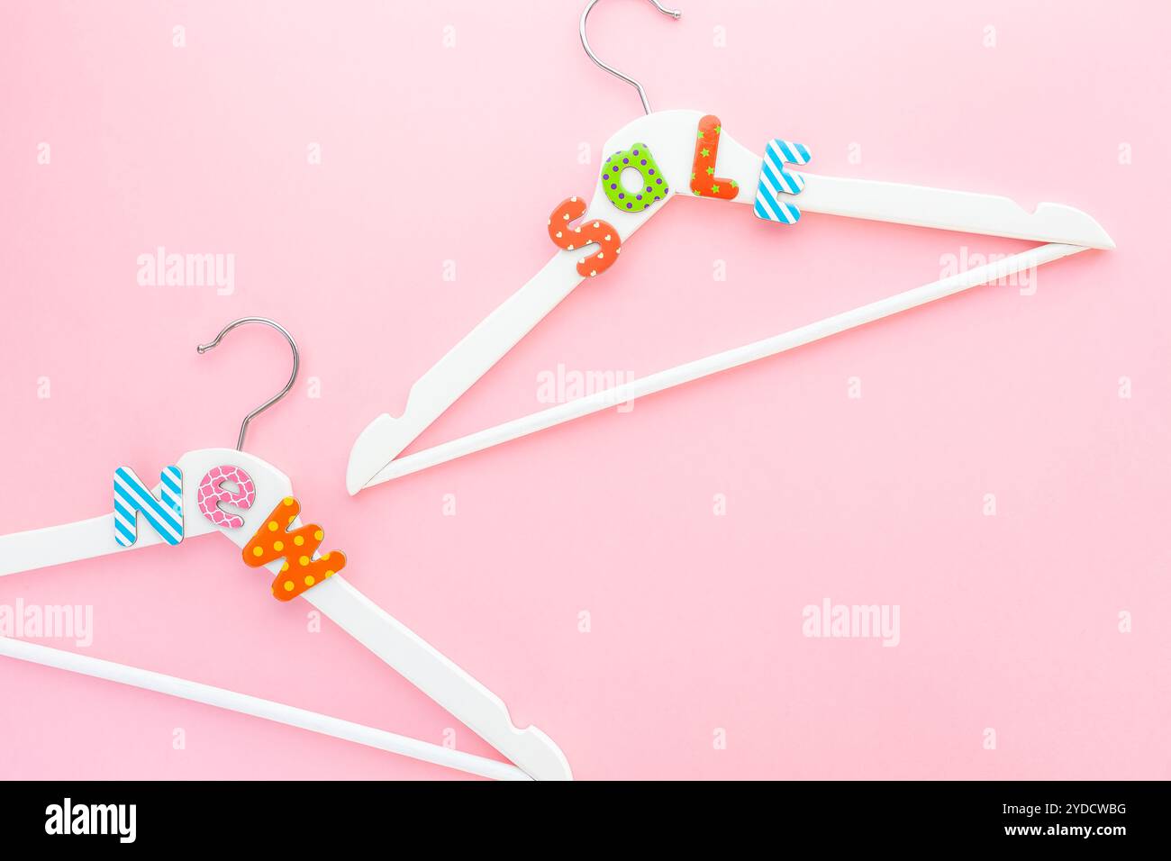 Appendiabiti bianchi con testo di vendita su sfondo rosa Foto Stock
